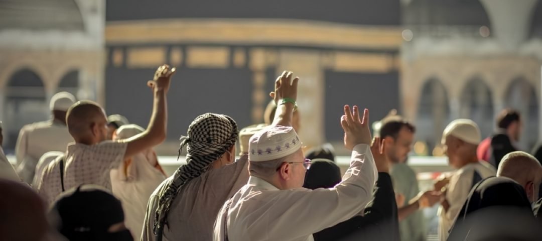 foto orang mengangkat tangan di mekkah